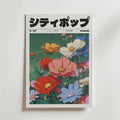 Garden Reverie Poster by Bozetto påminner om ett omslag till ett popmagasin i en retrostad, med livfulla blommor som blommar mot en grön bakgrund och fet japansk text högst upp och mindre text nedanför.