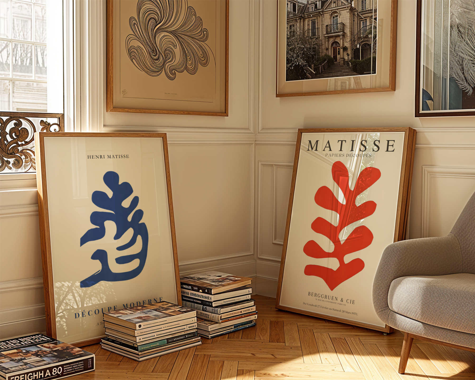 Bozetto Bundle 2-pack Henri Matisse No. 1 har två inramade affischer - en blå och en röd - som vilar på golvet vid en solbelyst vägg, med bokhögar och en grå stol som bidrar till den här konstnärliga samlingens charm.