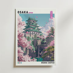 Osaka Castle Poster från Bozetto föreställer Osaka Castle med körsbärsblommor och svävande rosa kronblad, mot berg. Engelsk och japansk text ingår på denna stiliserade design.