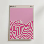Bozetto Bauhaus Pink Waves No.2 Poster föreställer abstrakta rosa och vita vågor på en ljus bakgrund med "BAUHAUS 1919" högst upp - perfekt för stilren inredning eller för att addera modern konst till ditt rum.